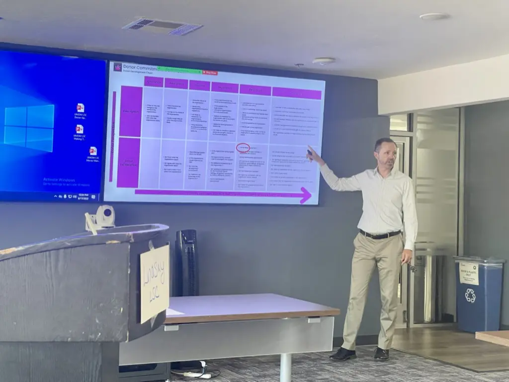 Man presenting in front of a screen.