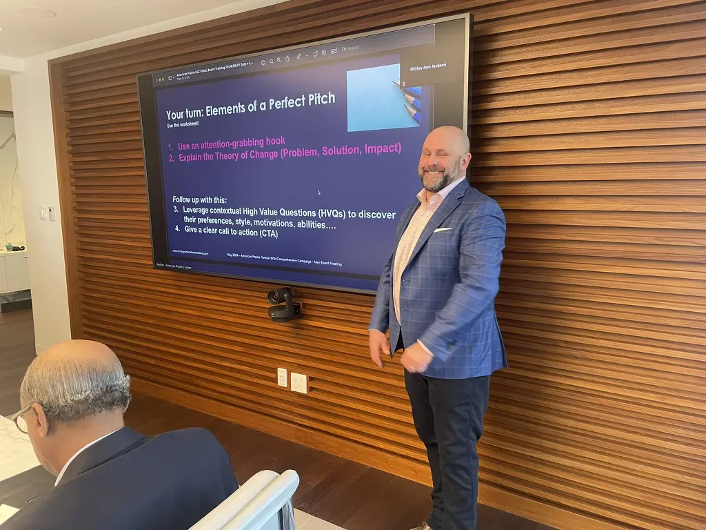 Man presenting in front of a screen.