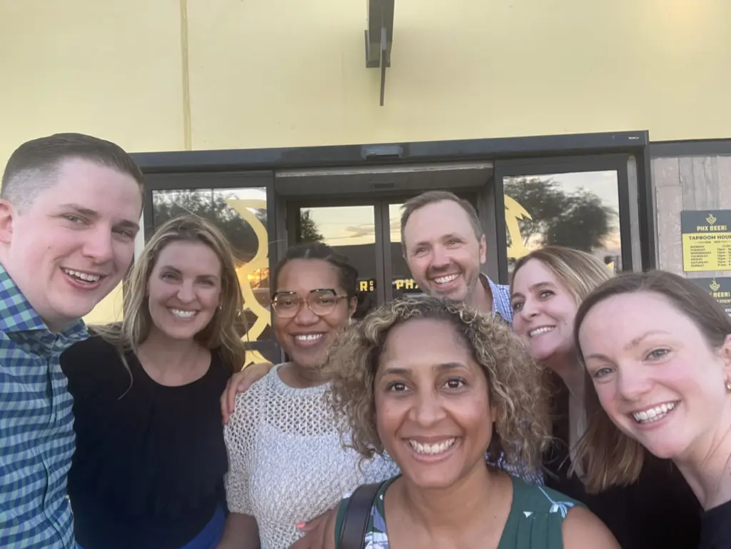 Group of people smiling outside a building.