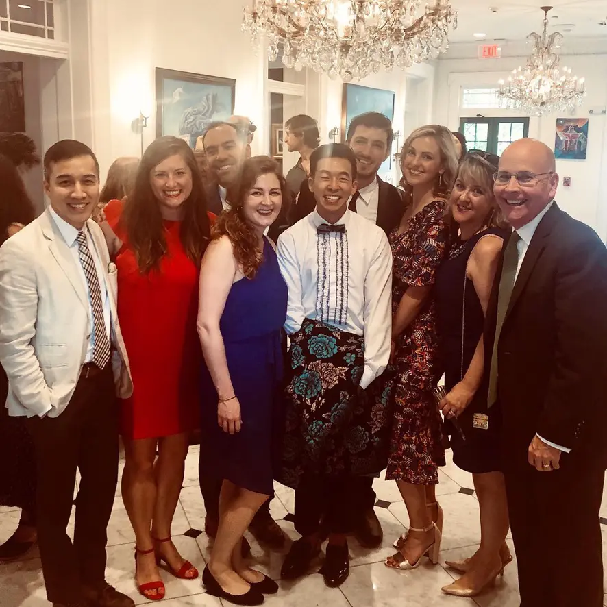Group of people smiling at formal event.