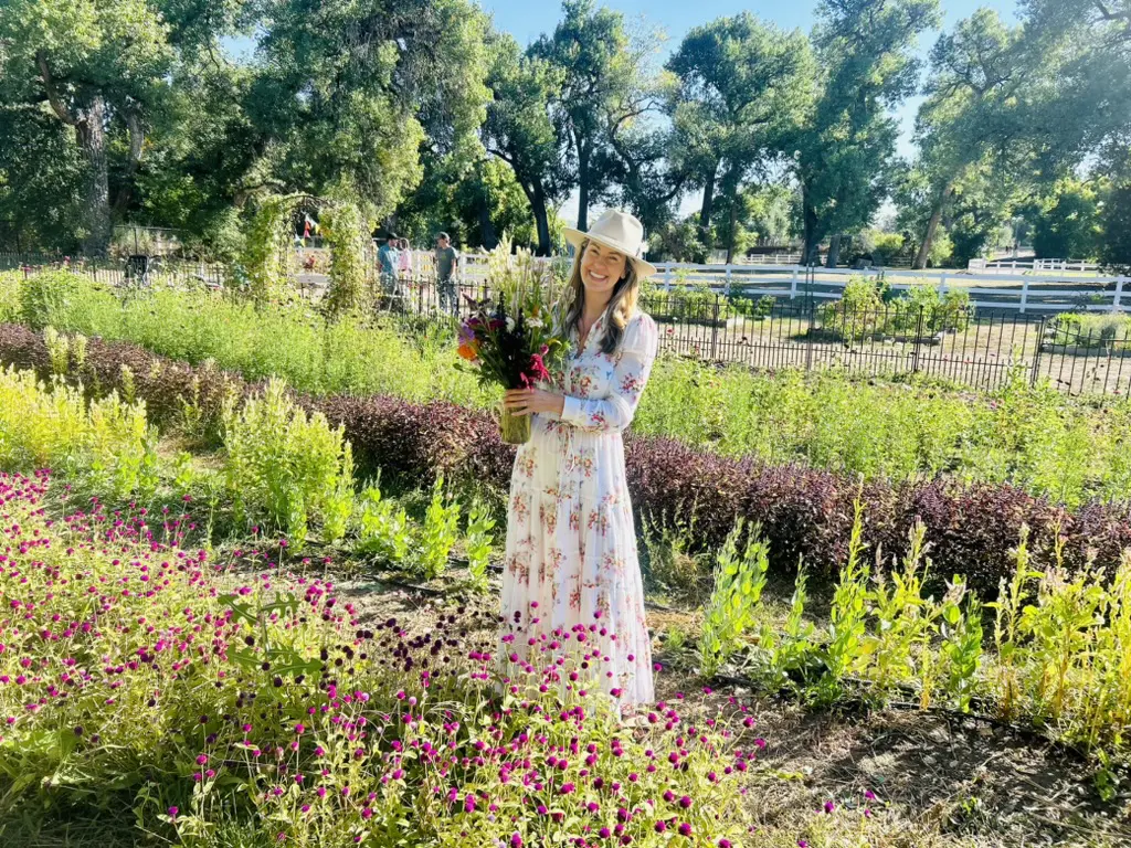 Woman in garden holding a flower bouquet.