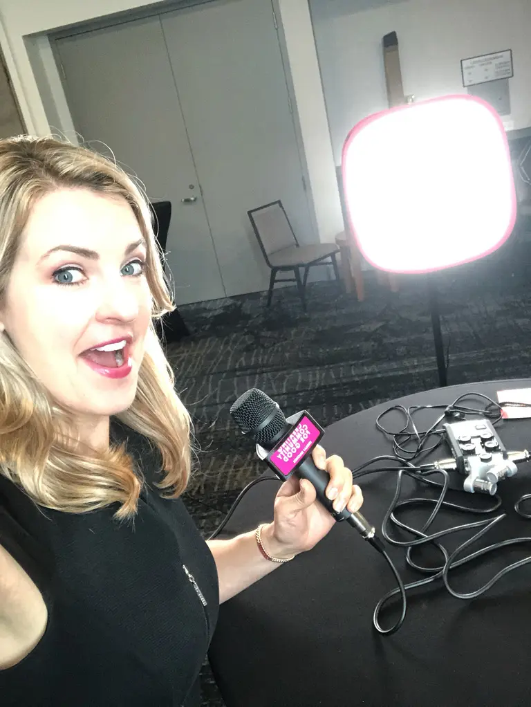 Woman holding microphone in front of camera.