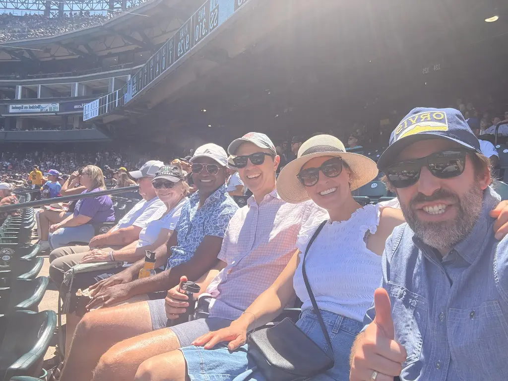 Friends enjoying a sunny day at stadium.