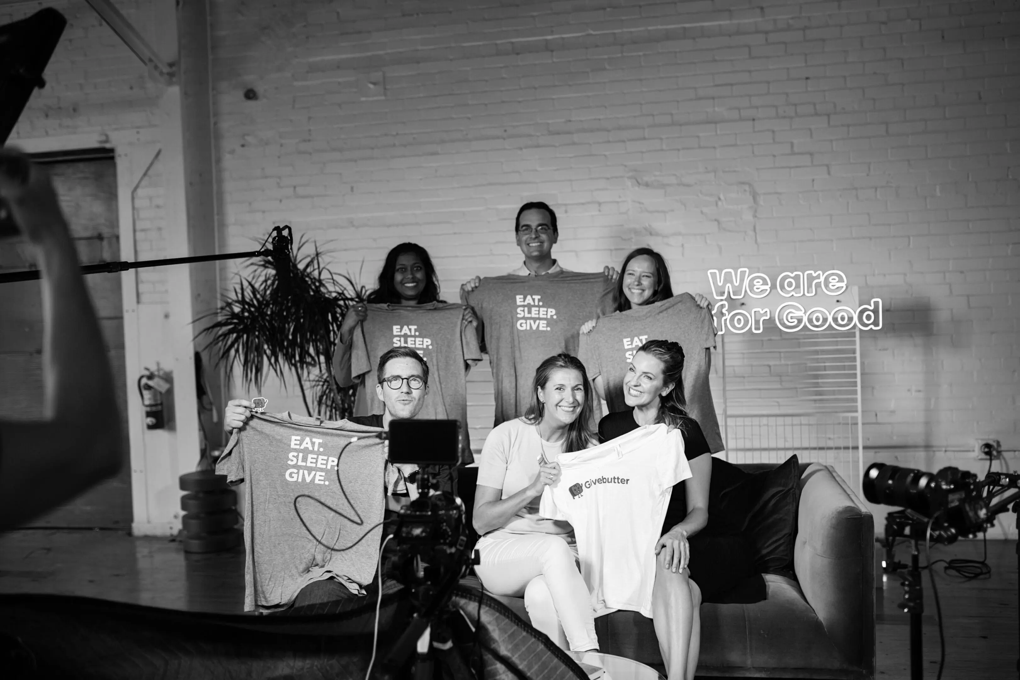 Group holding shirts, smiling for camera.
