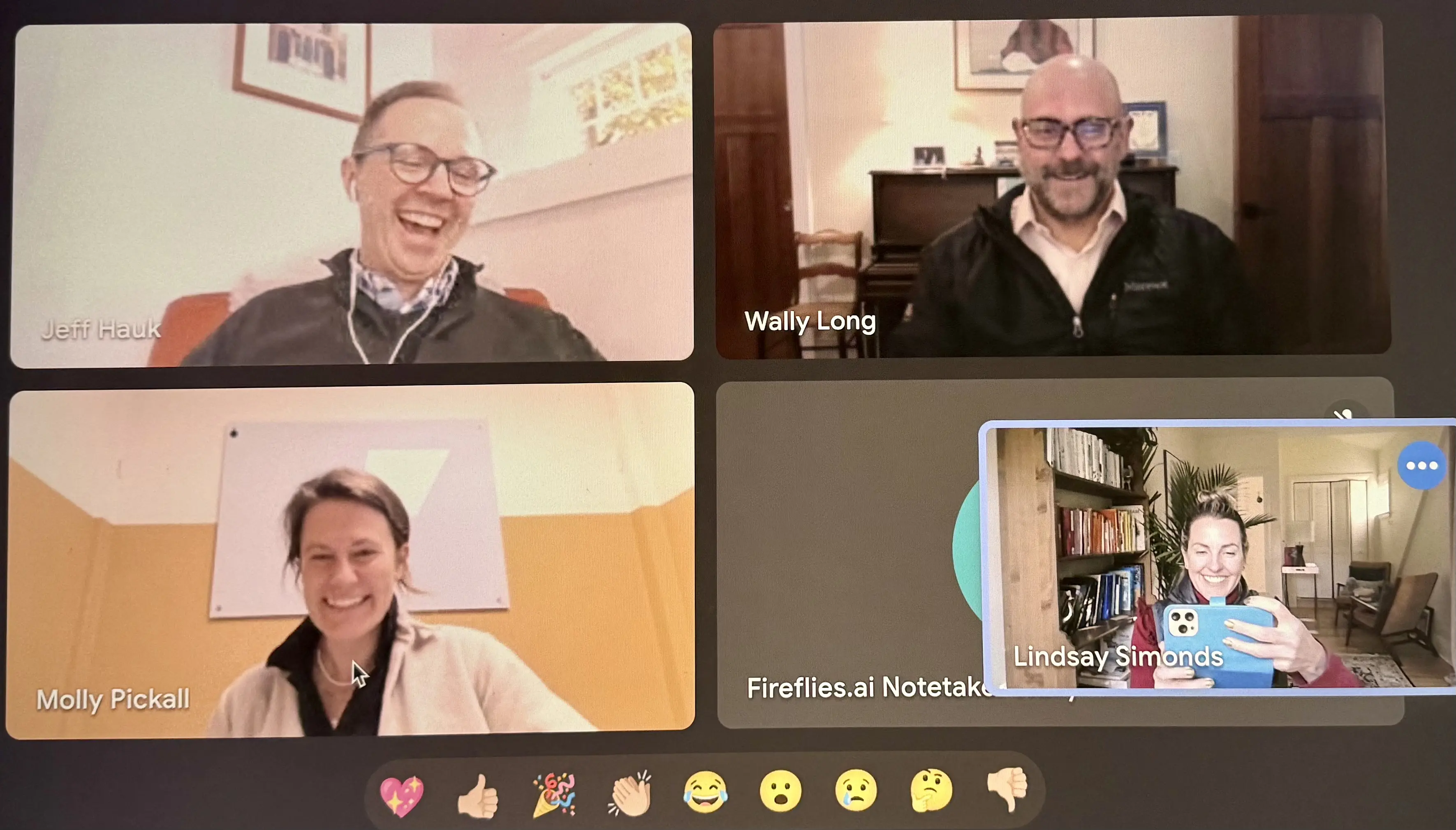 Video conference with four smiling participants.