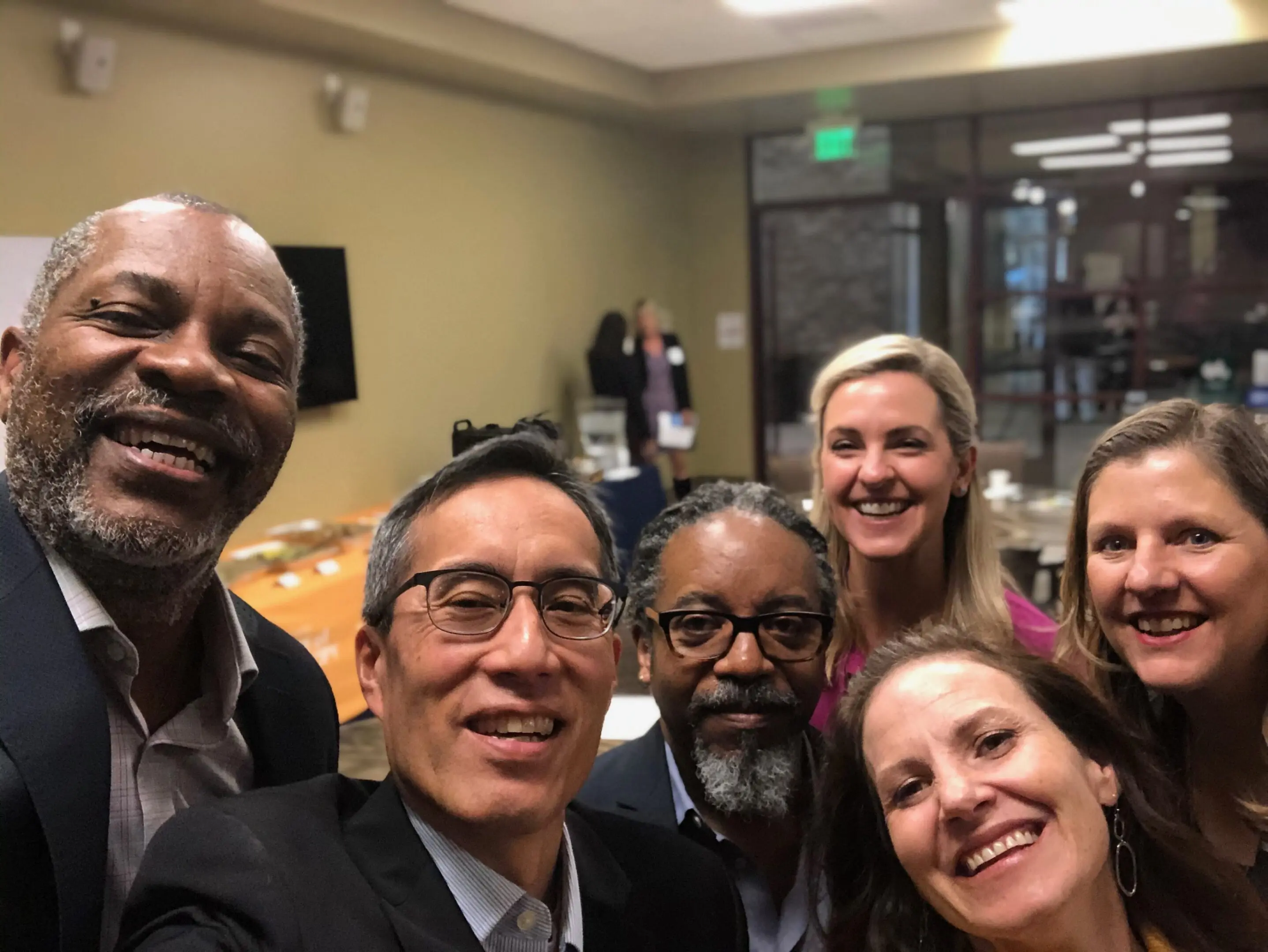 Group of people smiling at a gathering.
