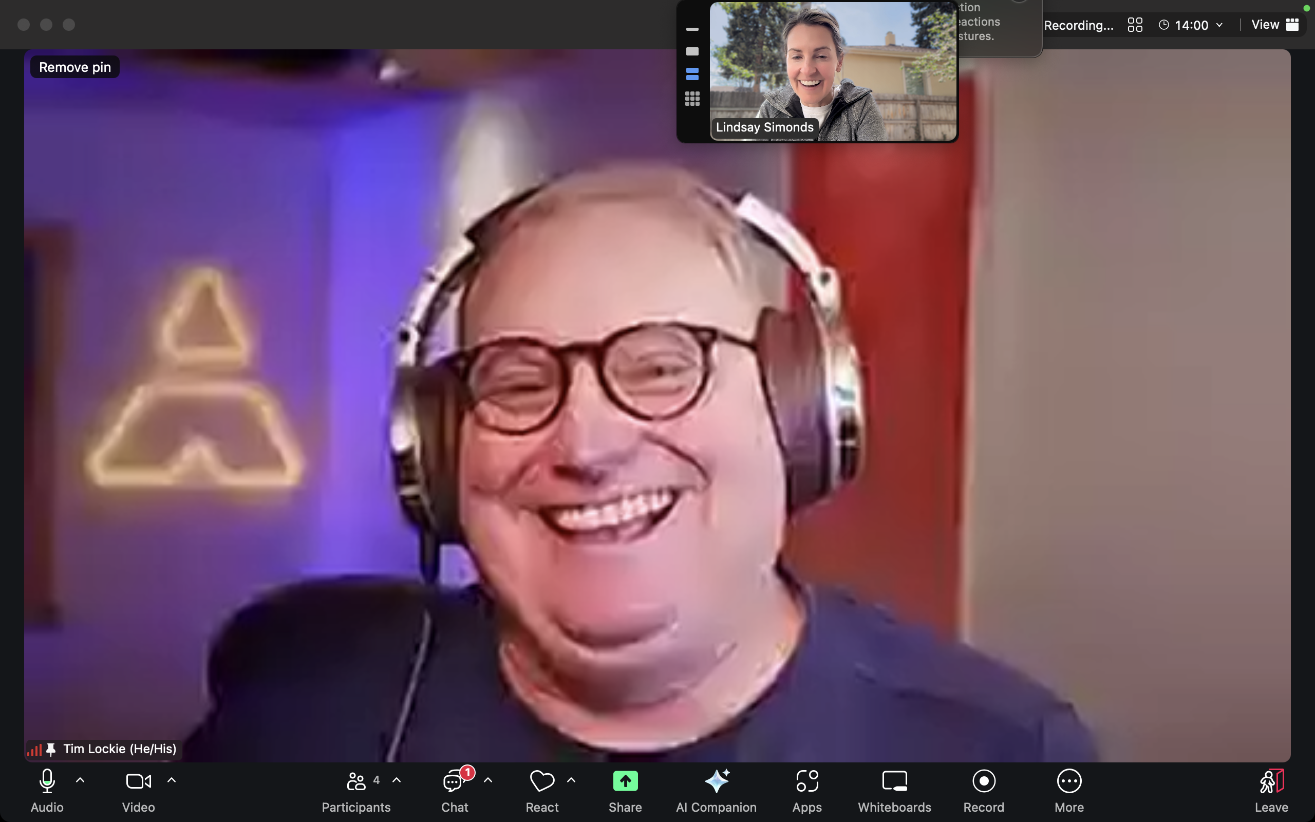 Smiling person wearing headphones on video call.